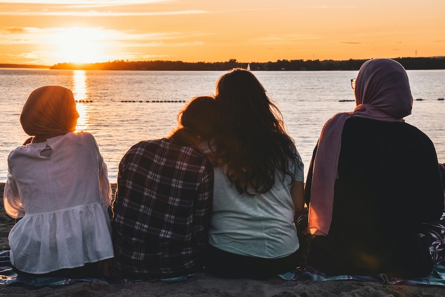 teenage friends sitting next to the lake during a sunset | The Peaceful Mind Counseling Center