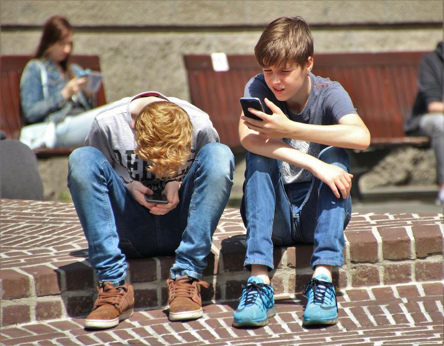 Teens on their phone | The Peaceful Mind Counseling Center